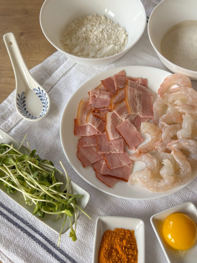  Banh xeo - wietnamskie naleśniki z krewetkami Chrupiący naleśnik, soczysta krewetka i aromatyczny boczek – wszystko to znajdziesz w Banh Xeo. Ten wietnamski przysmak przeniesie Cię prosto do serca Azji Południowo-Wschodniej. Obiad w 20 minut? Tak, to możliwe – ten przepis jest prosty, egzotyczny i pyszny.