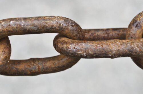 Symboliczne przedstawienie kajdan. Historia niewolnictwa: Analiza handlu ludźmi w Gambii, Europie i starożytnym Rzymie. Ewolucja i upadek instytucji niewolnictwa na przestrzeni wieków.