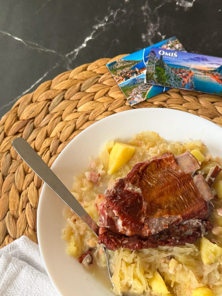 Istarska jota to esencja zimowego comfort foodu: aromatyczna kapusta kiszona, miękkie ziemniaki i sycąca fasola tworzą gęstą, rozgrzewającą zupę z charakterem. Całość dopełniają żeberka i boczek, które nadają jej głębi i wyrazistości. Poznaj prosty przepis na chorwacki kapuśniak, który smakuje domowo, treściwie i kojąco.